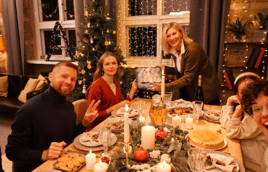 Imagen de una familia departiendo en Navidad una cena, quizas un almuerzo, felices por la fiestas de Navidad y centrados en el momento, no en los conflictos del mes.