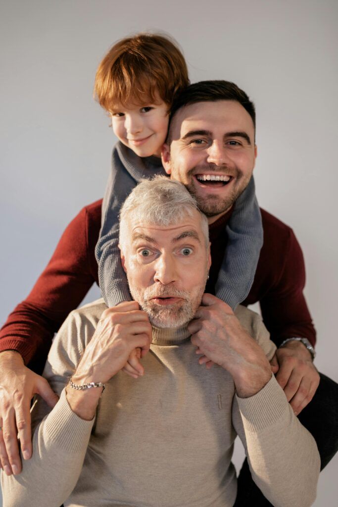 Conclusiones sobre La Reconciliación con tu padre. Tres generaciones de una familia: abuelo, padre e hijo sonrientes juntos, simbolizando la importancia de la conexión familiar, la integración de la herencia y la necesidad de honrar y transmutar las enseñanzas de los antepasados.
