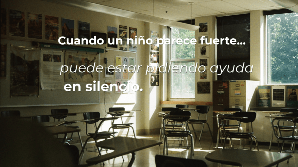 Aula vacía iluminada por la luz natural, con un mensaje sobre un niño que parece fuerte, pero puede necesitar ayuda emocional.